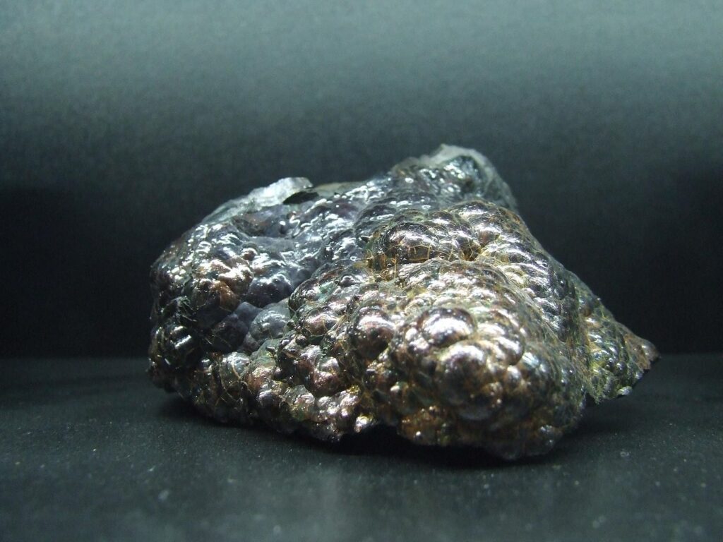 Hämatit Rohstein mit nierenförmiger metallischer Oberfläche auf dunklem Hintergrund
