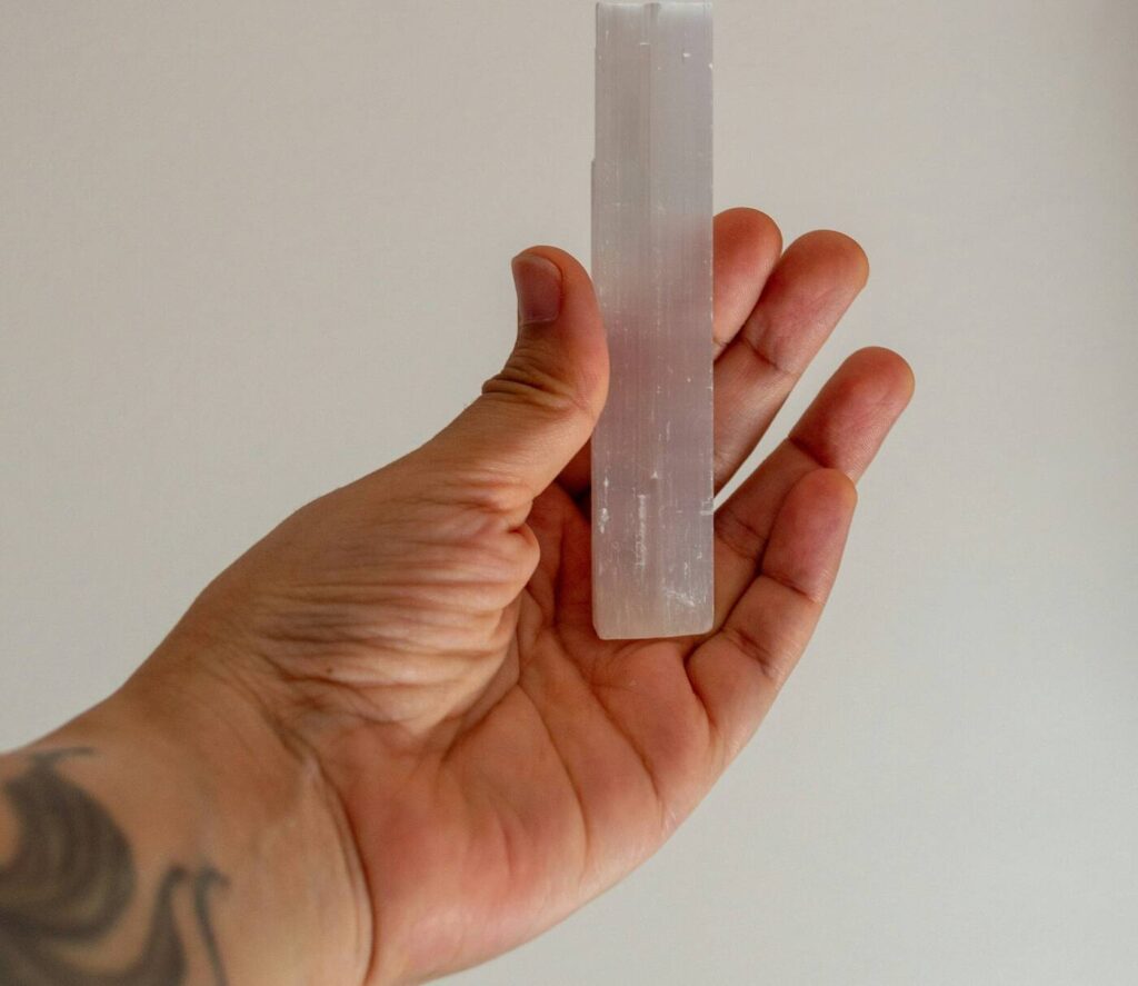Weiße Selenit-Wand mit faseriger Struktur in der Hand gehalten